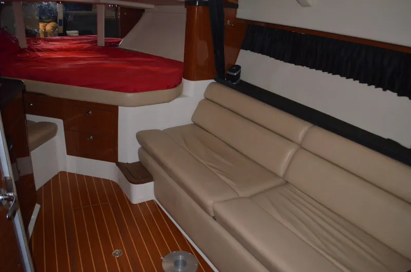 Slide: The Image of Interior of 2008 Regal 3360 Window Express with beige seating and red bedding. - 9