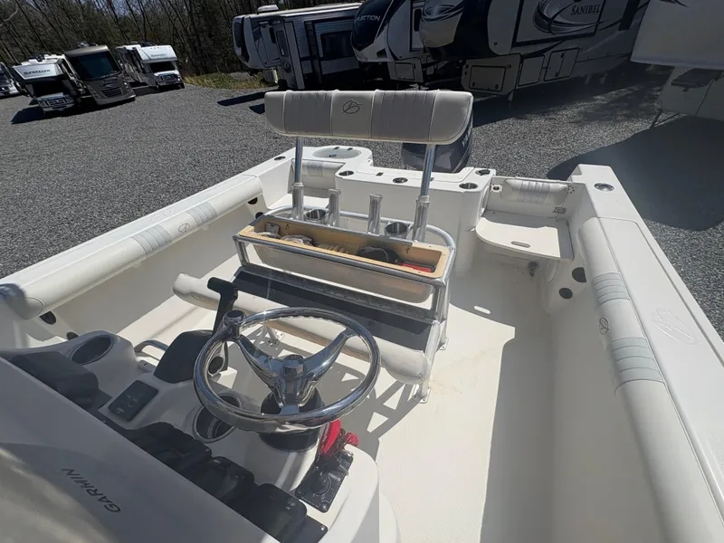 Slide: The Image of 2011 Sailfish 218 boat interior with steering wheel and seating, parked near RVs. - 10