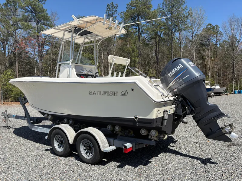 Slide: The Image of 2011 Sailfish 218 boat on trailer with Yamaha outboard motor, parked on gravel. - 2