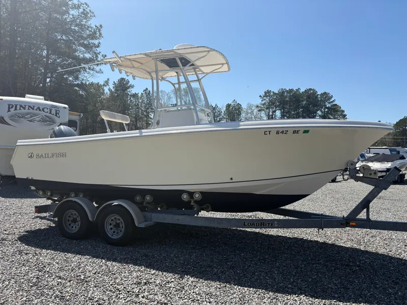 Slide: The Image of 2011 Sailfish 218 boat on trailer, parked outdoors under clear sky. - 5
