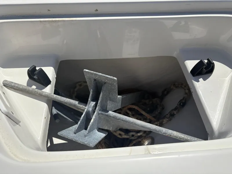 Slide: The Image of Anchor storage compartment on a 2011 Sailfish 218 boat, featuring a metal anchor and chain. - 7