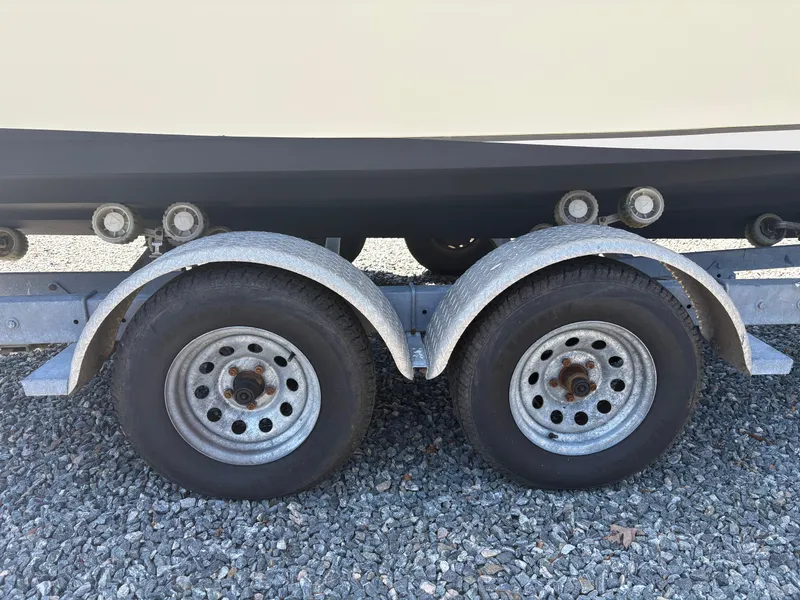 Slide: The Image of Trailer wheels for 2011 Sailfish 218 boat on gravel surface. - 8