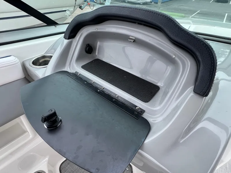 Slide: The Image of 2019 Chaparral 23 H2O Surf boat dashboard storage compartment with open lid. - 11