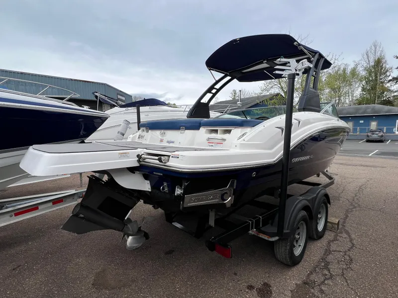 Slide: The Image of 2019 Chaparral 23 H2O Surf boat on trailer, parked outdoors. - 2