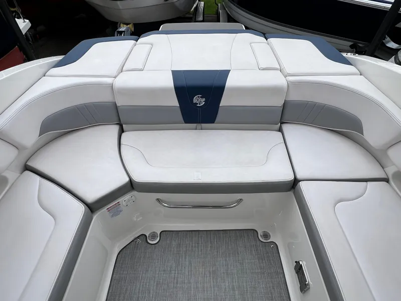 Slide: The Image of 2019 Chaparral 23 H2O Surf boat interior with cushioned seating and sleek design. - 5