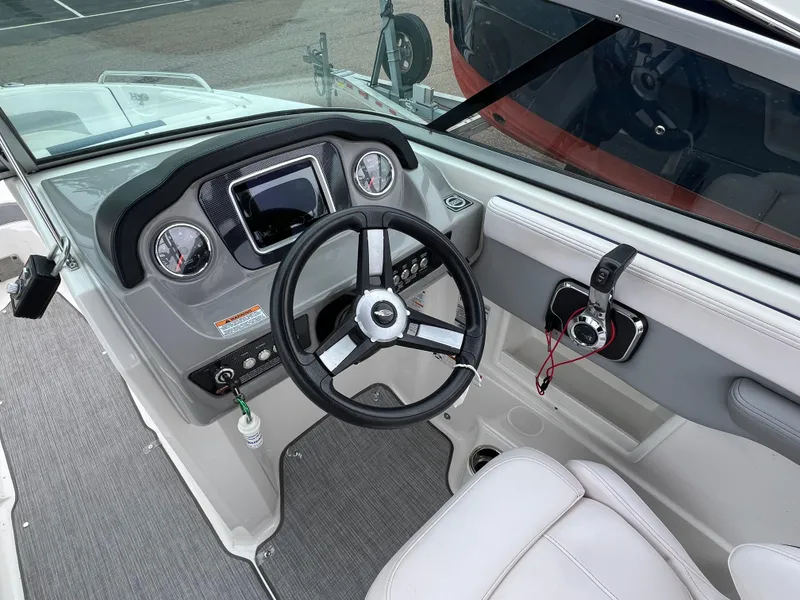 Slide: The Image of 2019 Chaparral 23 H2O Surf boat dashboard with steering wheel and controls. - 9