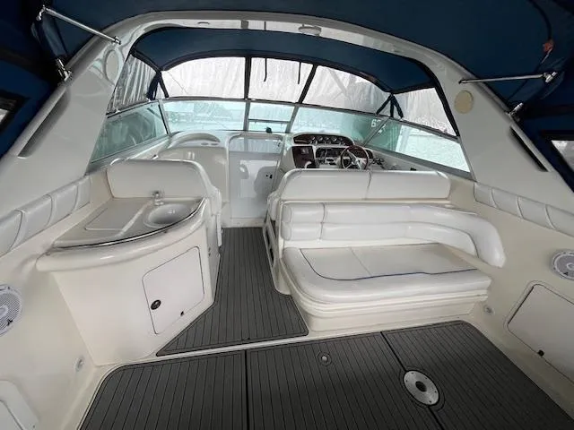 Slide: The Image of 1996 Sea Ray 330 Sundancer interior with white seating and blue canopy. - 10