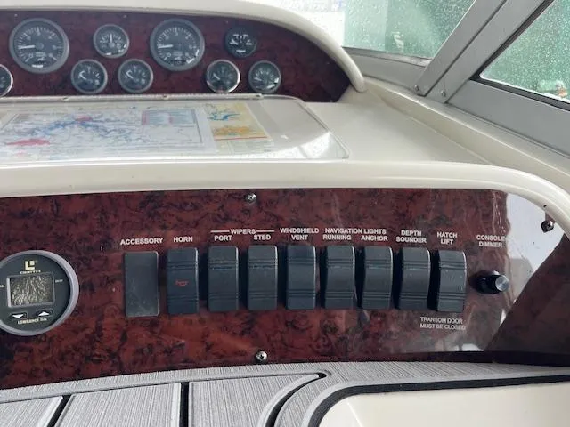 Slide: The Image of Control panel of a 1996 Sea Ray 330 Sundancer boat with various switches and gauges. - 18