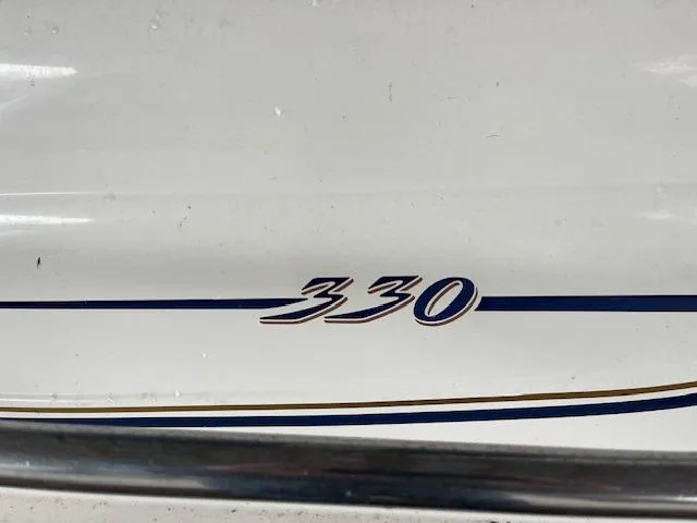 Slide: The Image of 1996 Sea Ray 330 Sundancer boat model emblem on white hull. - 19