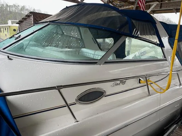 Slide: The Image of 1996 Sea Ray 330 Sundancer boat with blue canopy, docked under shelter. - 2