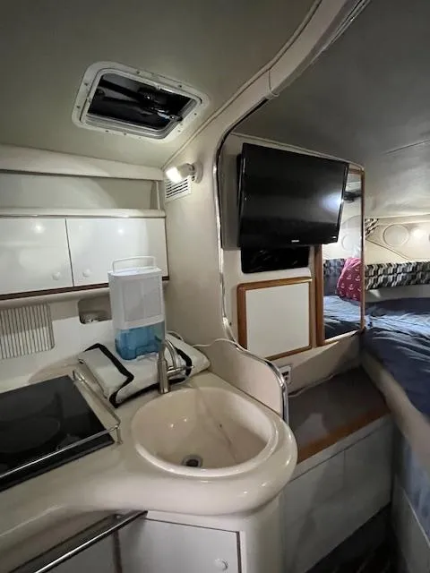 Slide: The Image of Interior of 1996 Sea Ray 330 Sundancer with kitchenette, sink, and mounted TV. - 23