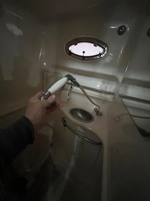 Slide: The Image of Interior of 1996 Sea Ray 330 Sundancer bathroom with sink and handheld showerhead. - 29