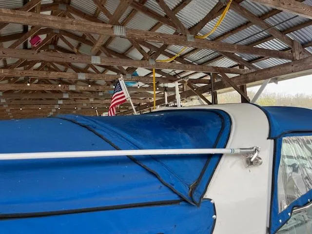 Slide: The Image of 1996 Sea Ray 330 Sundancer with blue cover in a wooden boathouse. - 5