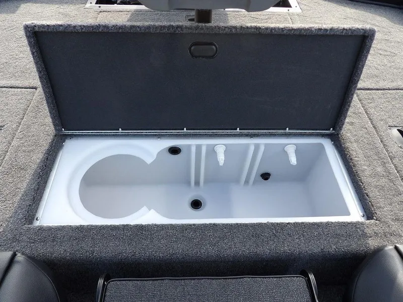 Slide: The Image of Open storage compartment in 2025 Crestliner XFC 189 boat, featuring dual drainage outlets. - 11
