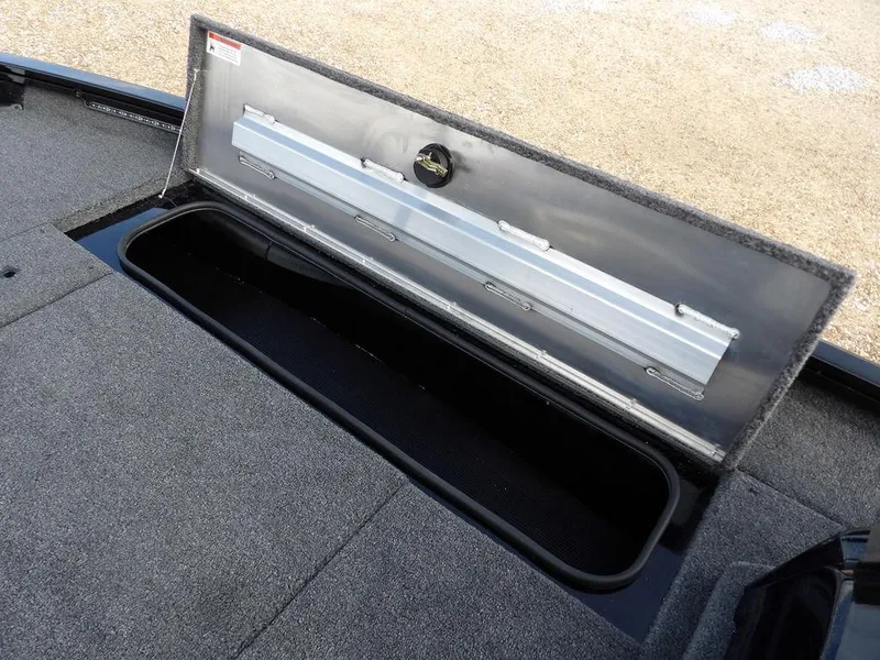 Slide: The Image of Open storage compartment in 2025 Crestliner XFC 189 boat, featuring carpeted interior. - 26