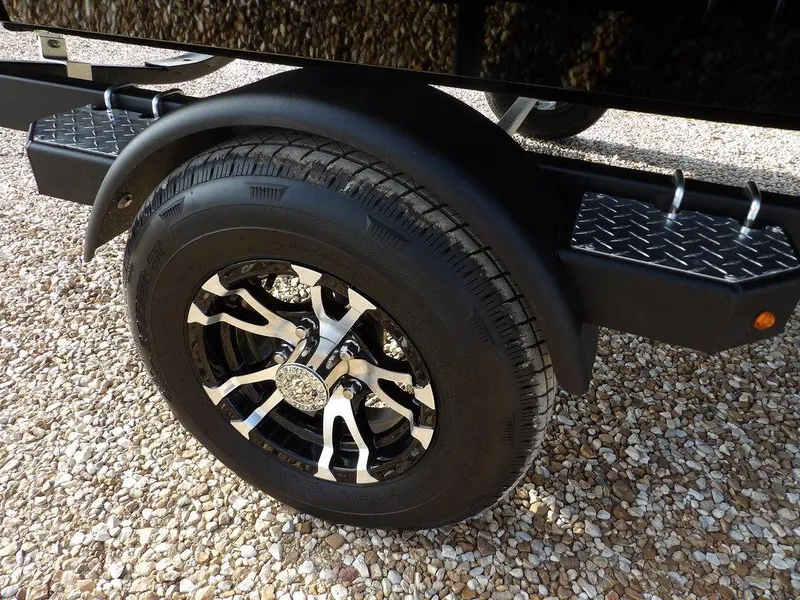 Slide: The Image of 2025 Crestliner XFC 189 trailer wheel on gravel surface, featuring stylish alloy rim. - 31