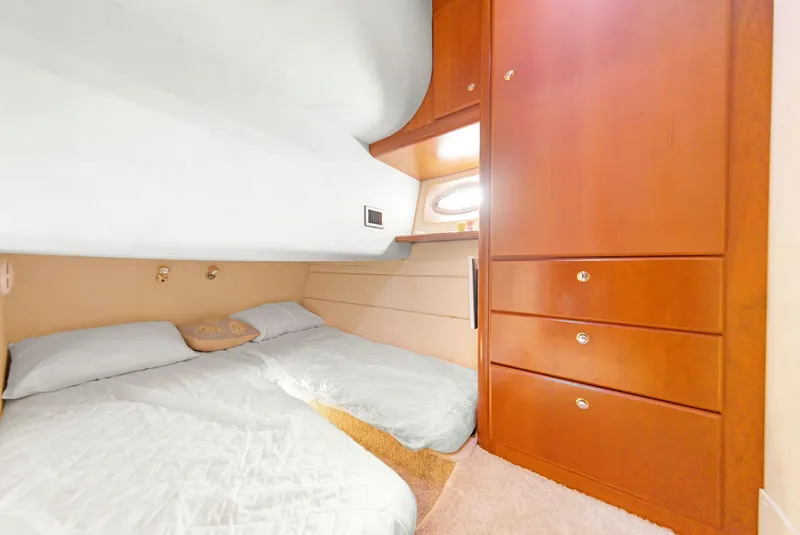 Slide: The Image of 2007 Silverton 45 Convertible yacht cabin with cozy bed and wooden storage cabinets. - 17
