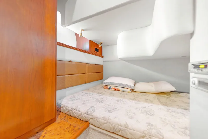 Slide: The Image of 2007 Silverton 45 Convertible yacht interior cabin with bed and wooden accents. - 19