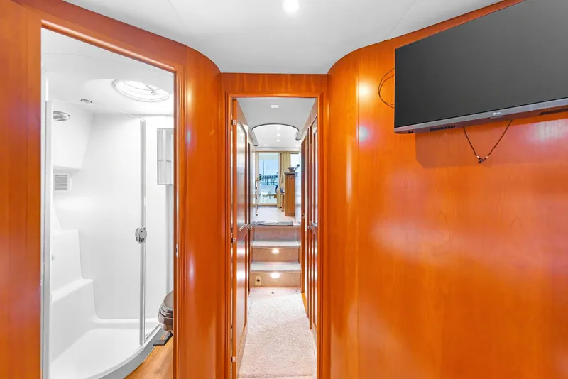Slide: The Image of Interior of 2007 Silverton 45 Convertible yacht, featuring hallway, shower, and mounted TV. - 24