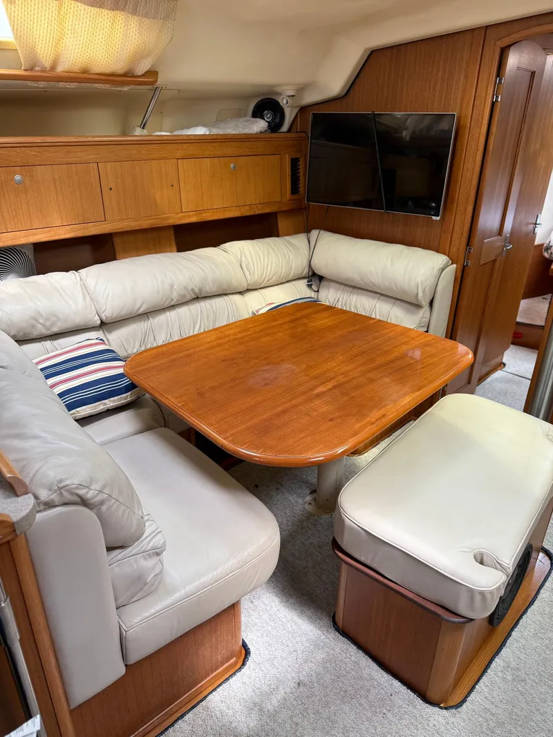 Slide: The Image of Cozy interior of 2001 Hunter 460 yacht with wooden table and cushioned seating. - 16