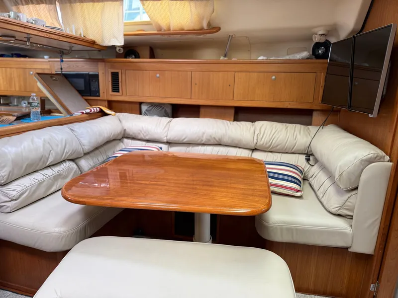 Slide: The Image of Interior of a 2001 Hunter 460 yacht with a cozy dining area and wooden table. - 17