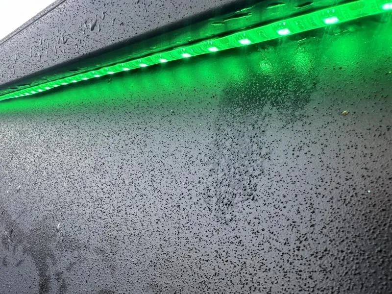 Slide: The Image of Close-up of Gator Tail 17/54 EXTREME SERIES 2025 with green LED lights and raindrops. - 16