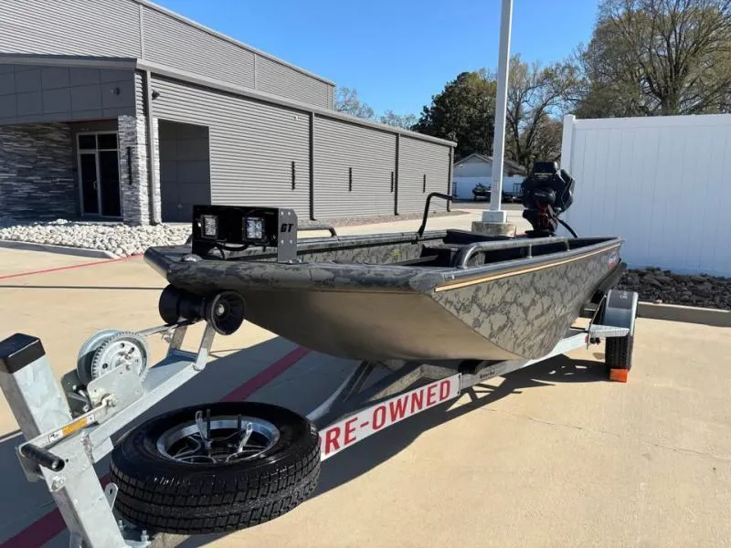 Slide: The Image of 2025 Gator Tail 17/50 Mid-Deck Savage Series boat on trailer, pre-owned, parked outdoors. - 2
