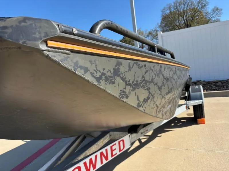 Slide: The Image of 2025 Gator Tail 17/50 Mid-Deck Savage Series boat on trailer, camo design. - 3
