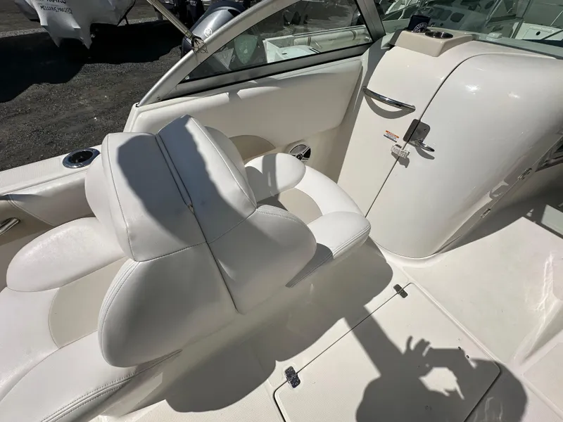 Slide: The Image of 2014 Robalo R227 Dual Console boat interior with white seating and storage compartments. - 10