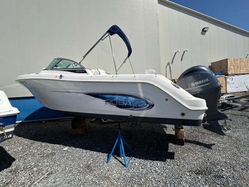 Slide: The Image of 2014 Robalo R227 Dual Console boat interior with seating and engine view. - 11