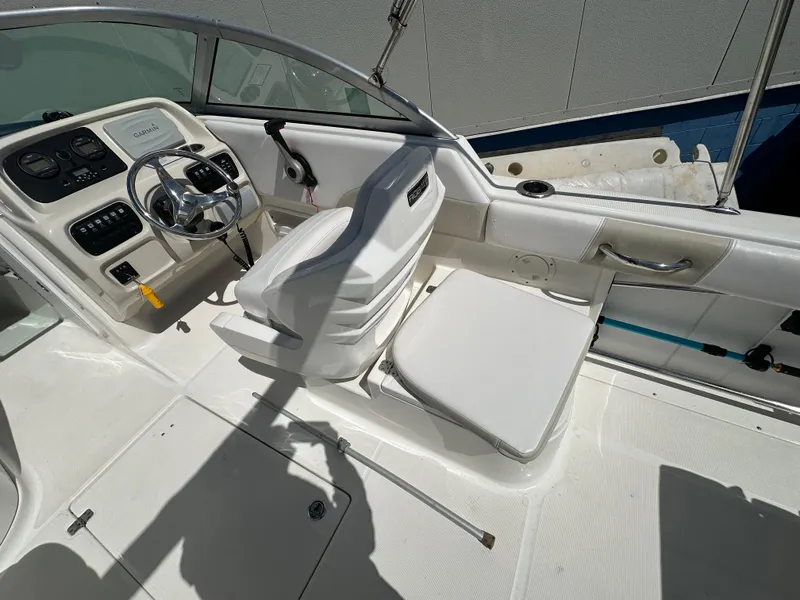 Slide: The Image of 2014 Robalo R227 Dual Console boat interior with white seating and storage compartments. - 15
