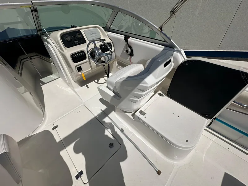 Slide: The Image of 2014 Robalo R227 Dual Console boat storage compartment open, revealing interior components. - 17