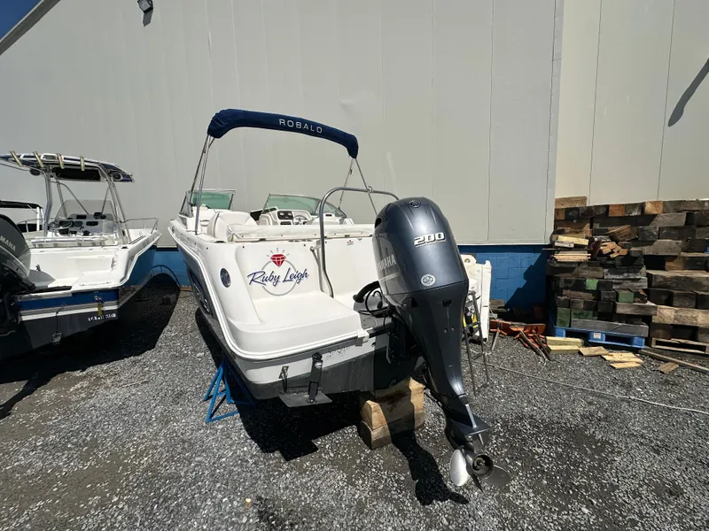 Slide: The Image of 2014 Robalo R227 Dual Console boat with Yamaha 200 engine, parked outdoors. - 2