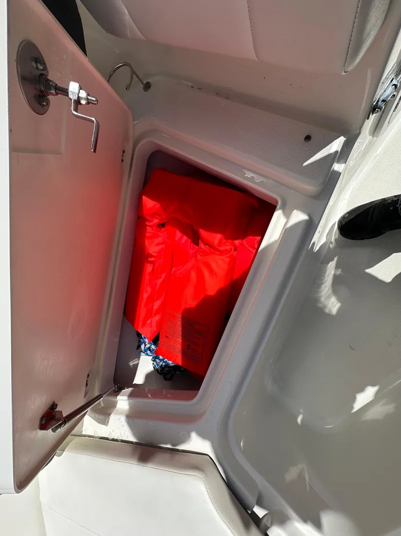 Slide: The Image of Open wooden cabinet with cleaning supplies on a 2014 Robalo R227 Dual Console boat. - 27