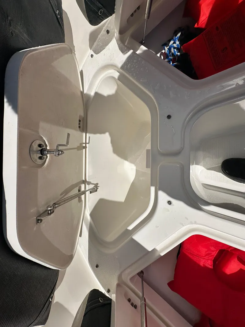 Slide: The Image of 2014 Robalo R227 Dual Console boat interior with seating and storage compartments. - 28