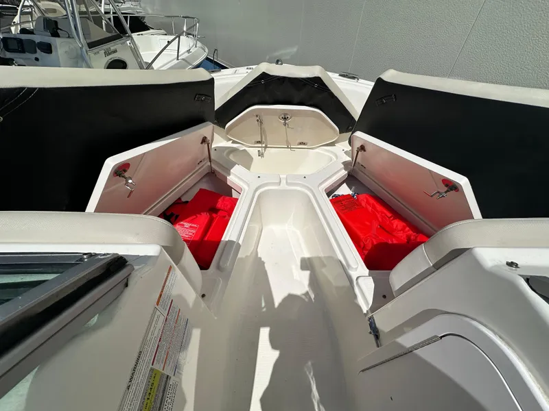 Slide: The Image of 2014 Robalo R227 Dual Console boat interior with open storage compartments and red life jackets. - 29