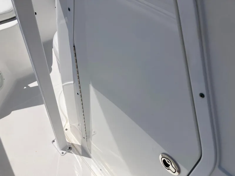 Slide: The Image of 2014 Sea Hunt 234 Ultra boat interior detail with white panel and metal hinge. - 14