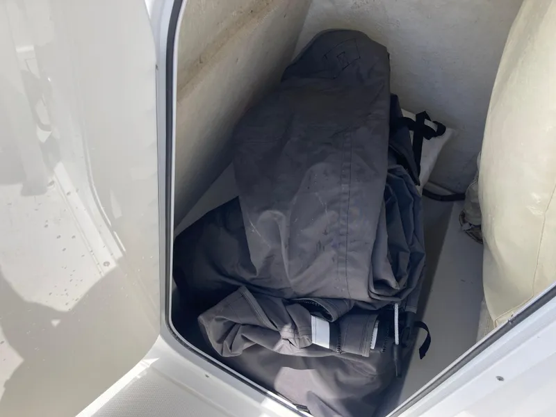 Slide: The Image of Storage compartment in a 2014 Sea Hunt 234 Ultra boat with folded black cover. - 15