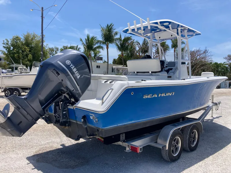Slide: The Image of 2014 Sea Hunt 234 Ultra boat on trailer with Yamaha outboard motor, parked outdoors. - 3