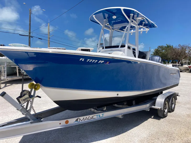 Slide: The Image of 2014 Sea Hunt 234 Ultra boat on trailer, blue hull, Magic Tilt trailer, sunny day. - 5