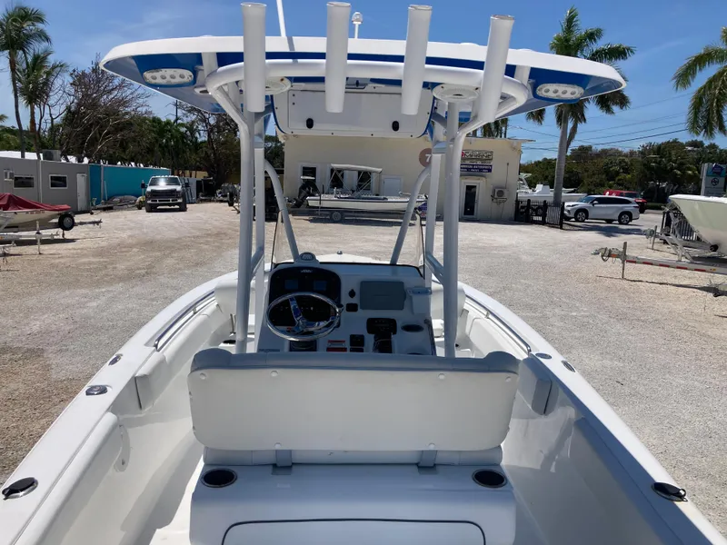 Slide: The Image of 2014 Sea Hunt 234 Ultra boat with center console, docked outdoors under clear skies. - 7