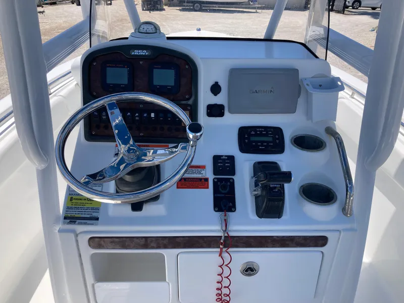 Slide: The Image of Console of a 2014 Sea Hunt 234 Ultra boat with steering wheel and navigation controls. - 8