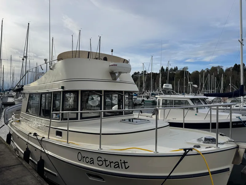 Slide: The Image of 2003 Camano Troll boat named "Orca Strait" docked at a marina with sailboats. - 0