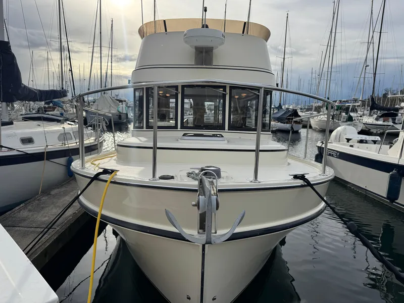 Slide: The Image of 2003 Camano Troll boat docked in a marina, surrounded by other vessels. - 1