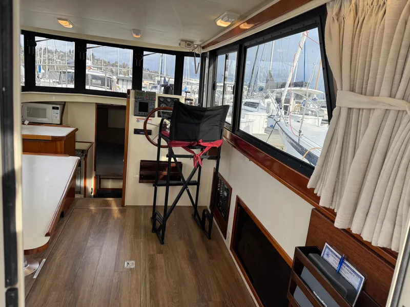 Slide: The Image of Interior of 2003 Camano Troll boat with helm, windows, and seating. - 11