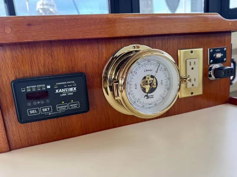 Slide: The Image of 2003 Camano Troll dashboard with Xantrex Link 1000, barometer, and electrical outlets. - 15