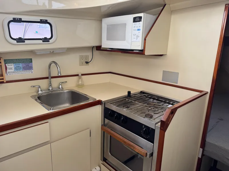 Slide: The Image of Compact kitchen in 2003 Camano Troll boat with stove, sink, and microwave. - 17