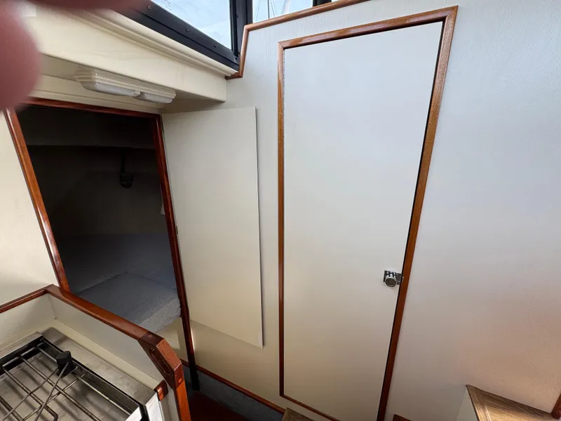 Slide: The Image of Interior of 2003 Camano Troll boat showing cabin door and compact kitchen area. - 19