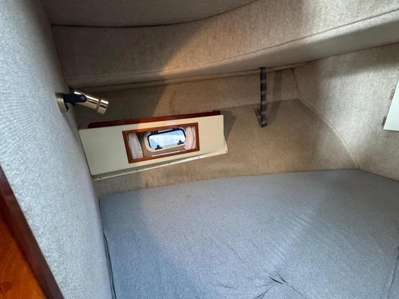 Slide: The Image of Cozy interior cabin of a 2003 Camano Troll boat with a small window. - 23