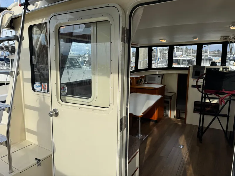 Slide: The Image of 2003 Camano Troll boat interior with dining area and navigation equipment. - 3